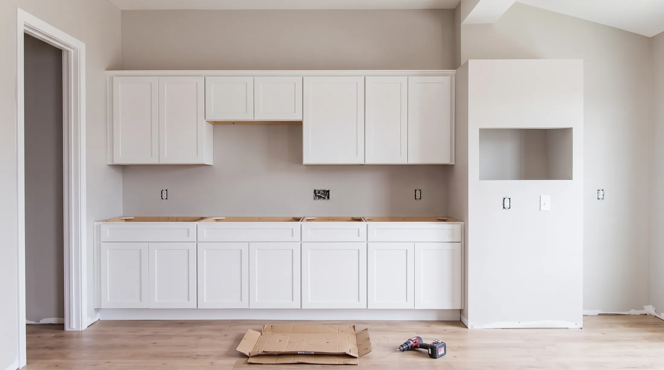The same room with the white shaker cabinets in and no counters yet