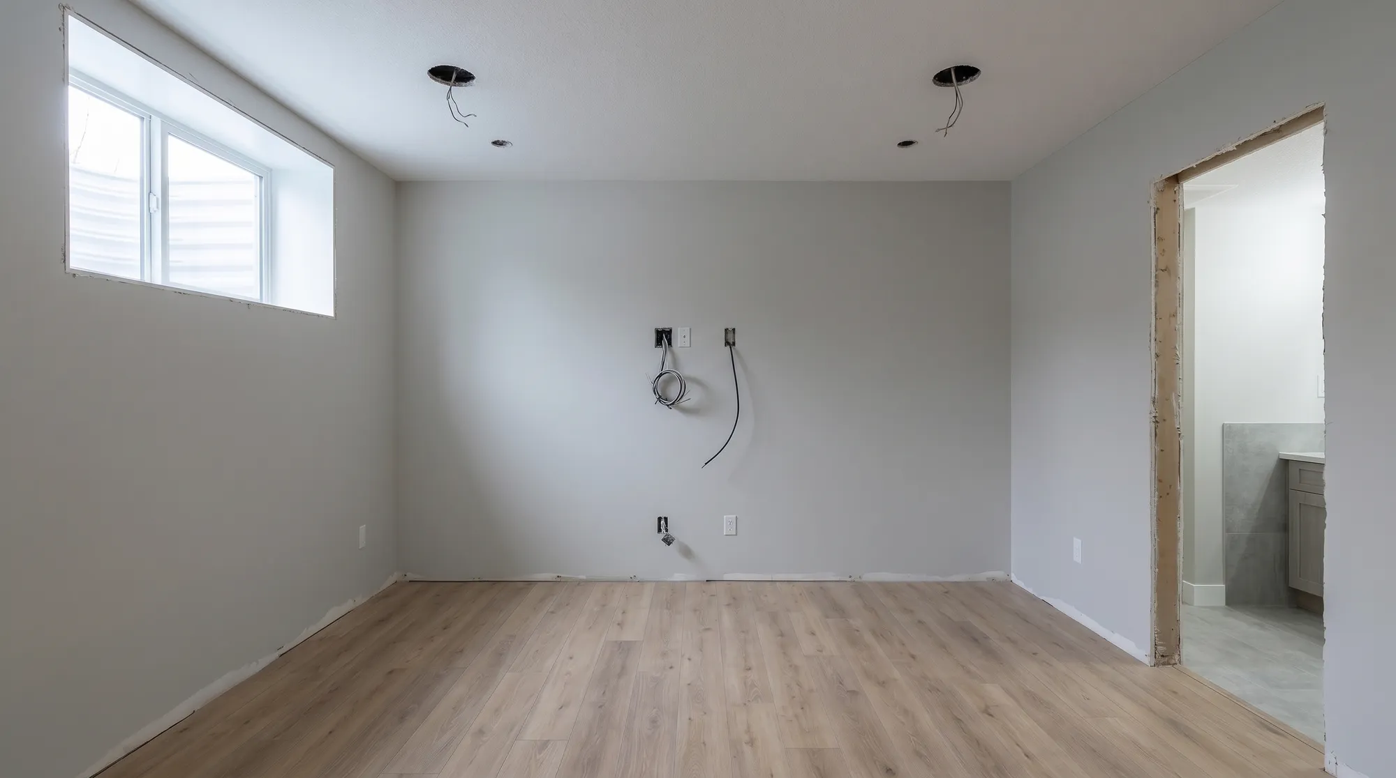 The same basement with the bathroom tiled through the doorway