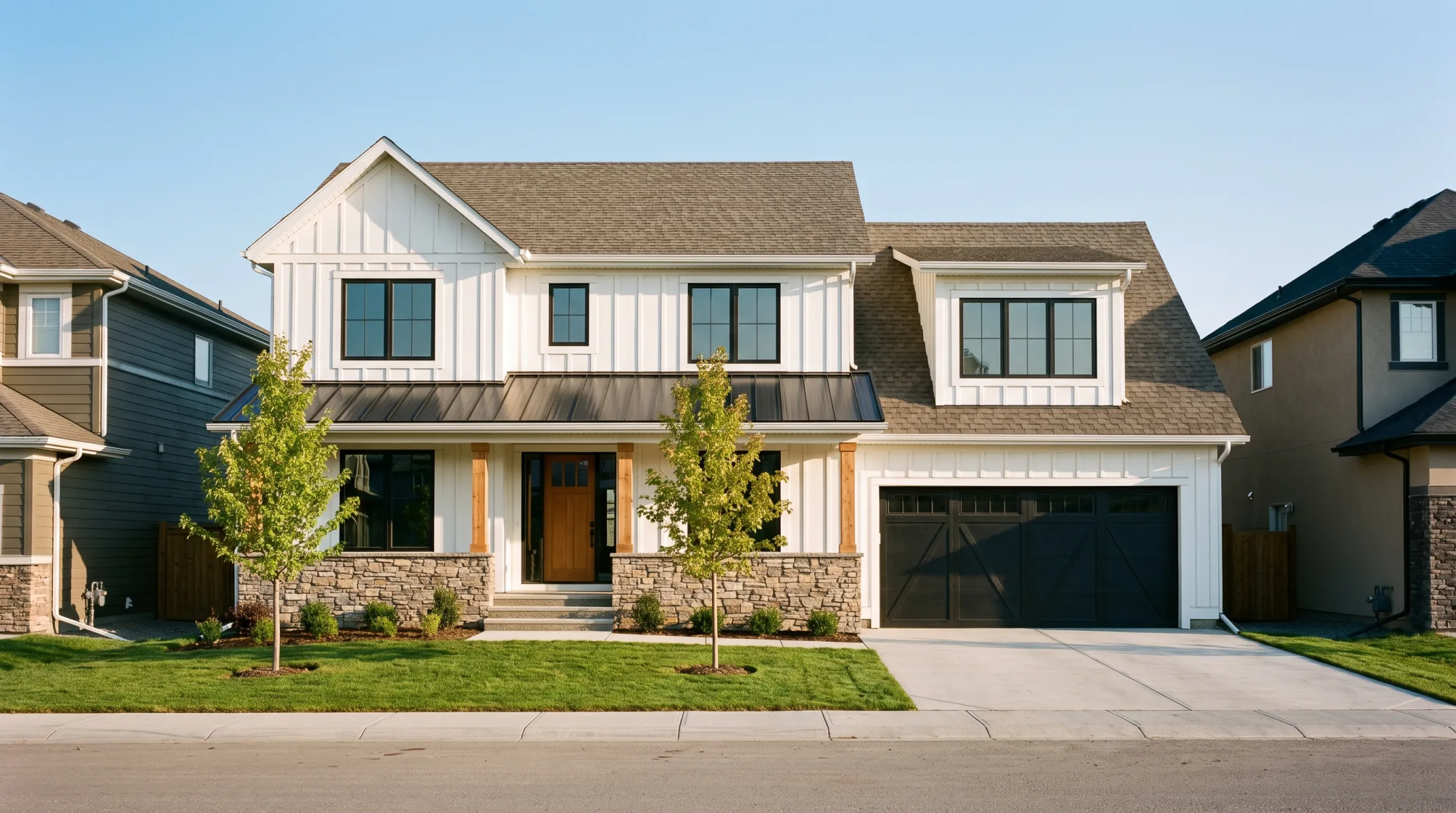 The same house with the sod down, two young maples and the shrubs planted